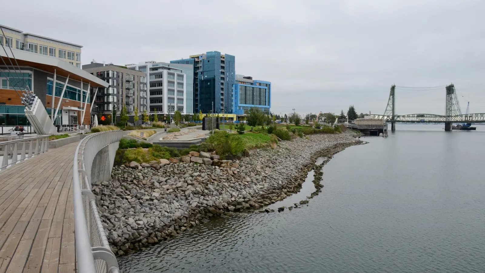 The Vancouver, Washington waterfront boardwalk, with apartment buildings on the left and the Interstate Bridge crossing the Columbia in the distance.