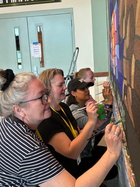 Guests painting a mural up close