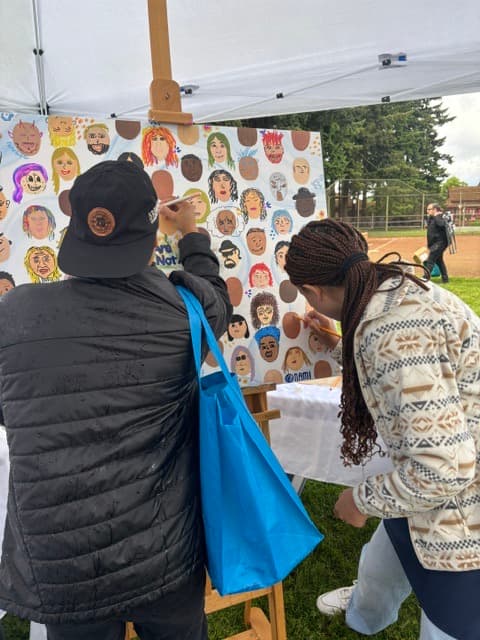 An outdoor collaborative community mural in progress